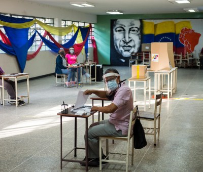 A few people sit at desks to monitor elections in Venezuela