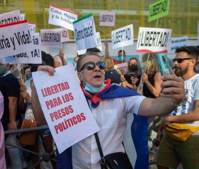 A group holds up signs in Cuba, protesting for freedom