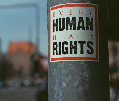 A sticker on a pole advocates for human rights
